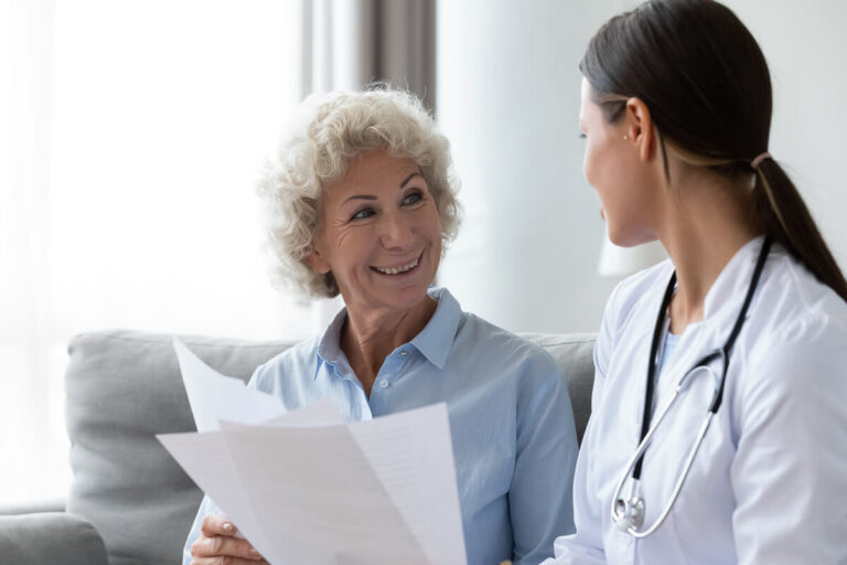 Signora sorridente che scambia documenti con un giovane medico